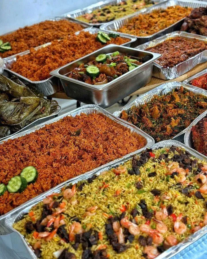 Trays of freshly cooked jollof rice and fried rice